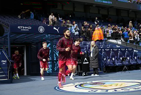 Liverpool's Joe Gomez comes onto the pitch before the FA Cup quarter-final soccer match between Manchester City and Liverpool in Manchester, England.