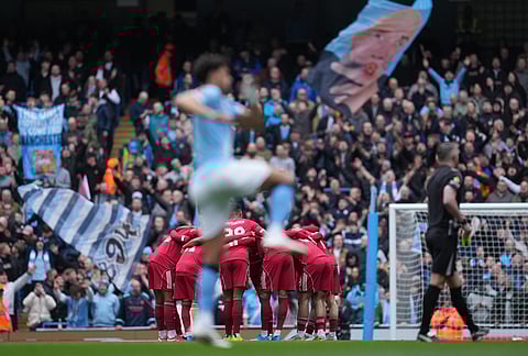 Liverpool players huddle before the FA Cup quarter-final soccer match between Manchester City and Liverpool in Manchester, England.
