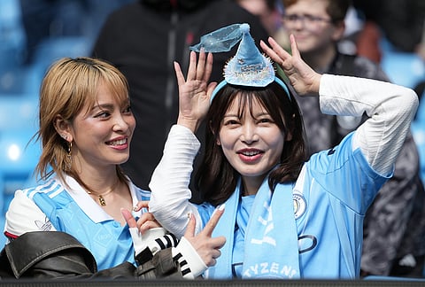 Mancheter City gans wait for the start of the FA Cup quarter-final soccer match between Manchester City and Liverpool in Manchester, England.