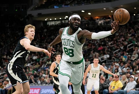 Boston Celtics' Neemias Queta (88) loses control of the ball in front of Milwaukee Bucks' AJ Green during the second half of an NBA basketball game in Milwaukee.