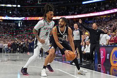 Denver Nuggets guard Jamal Murray, right, is fouled by San Antonio Spurs guard Stephon Castle during overtime of an NBA basketball game in Denver.