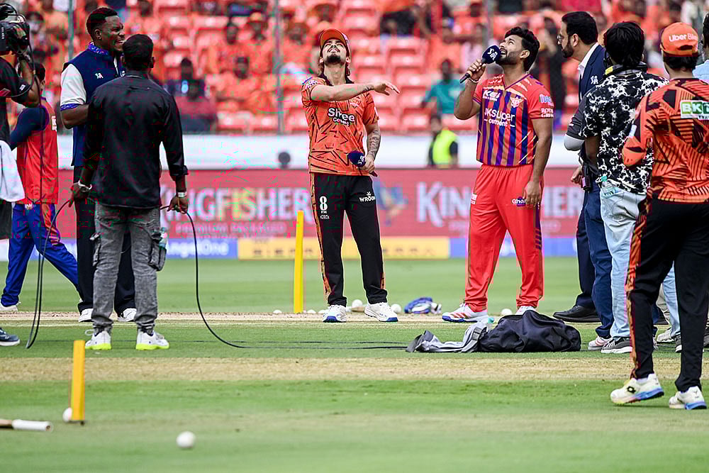 Sunrisers Hyderabad's captain Ishan Kishan, centre, flips the coin at the toss as Lucknow Super Giants' captain Rishabh Pant looks on, ahead of an Indian Premier League (IPL) 2026 T20 cricket match between Sunrisers Hyderabad and Lucknow Super Giants at the Rajiv Gandhi International Cricket Stadium, in Hyderabad, Telangana. - | Photo: PTI 