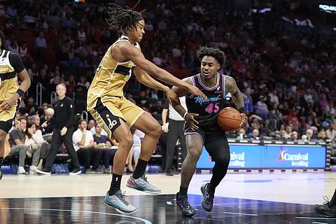 Washington Wizards guard Tre Johnson (12) defends Miami Heat guard Davion Mitchell (45) during the second half of an NBA basketball game in Miami.