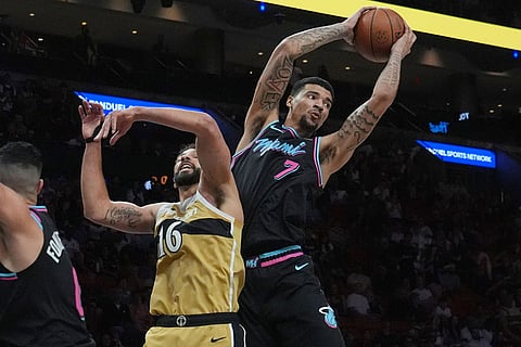 Miami Heat center Kel'el Ware (7) and Washington Wizards forward Anthony Gill (16) go after a rebound during the first half of an NBA basketball game in Miami.