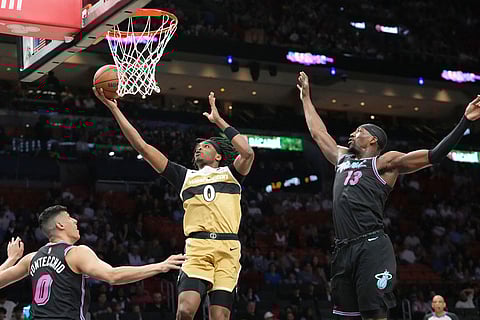 Washington Wizards guard Bilal Coulibaly (0) aims to score as Miami Heat forward Simone Fontecchio (0) and center Bam Adebayo (13) defend during the first half of an NBA basketball game in Miami.