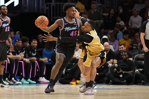 Washington Wizards guard Bub Carrington (7) defends Miami Heat guard Davion Mitchell (45) during the first half of an NBA basketball game in Miami.
