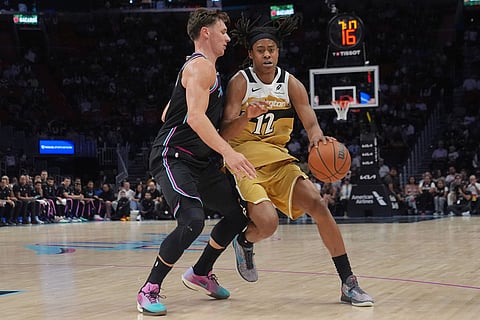 Miami Heat guard Pelle Larsson (9) defends Washington Wizards guard Tre Johnson (12) during the first half of an NBA basketball game in Miami.