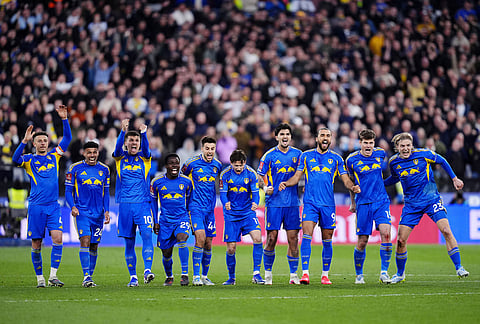 Leeds United's Dominic Calvert-Lewin, third right, and teammates celebrate in the penalty shoot-out during the English FA Cup quarterfinal soccer match between West Ham United and Leeds United, in London.