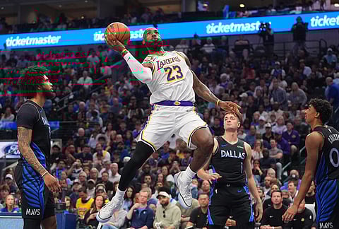 Los Angeles Lakers forward LeBron James (23) drives to the basket against Dallas Mavericks defenders John Poulakidas (1), Max Christie (00) and Naji Marshall during the first half of an NBA basketball game in Dallas.
