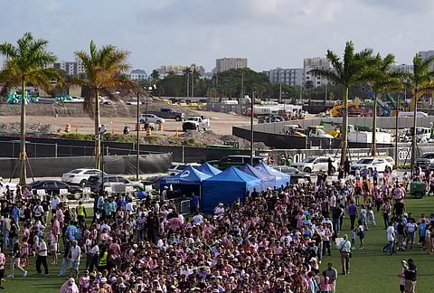Fans wait in line to enter Nu Stadium, as signs of ongoing work are seen behind, ahead of the team's first MLS soccer match in their new stadium, against Austin FC, in Miami.
