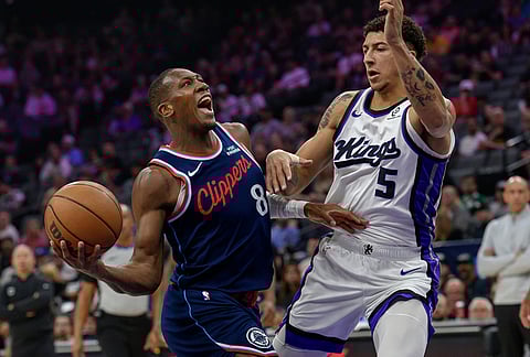Los Angeles Clippers guard Kris Dunn (8) drives past Sacramento Kings guard Nique Clifford (5) during the first half of an NBA basketball game 
in Sacramento, California.