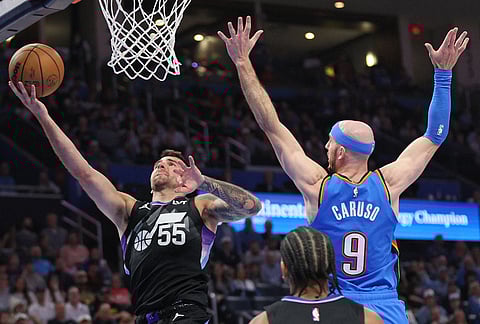 Utah Jazz guard John Konchar (55) looks to score past Oklahoma City Thunder guard Alex Caruso (9) during the second half of an NBA basketball game in Oklahoma City.