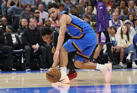 Utah Jazz guard Ace Bailey, left, and Oklahoma City Thunder guard Ajay Mitchell, right, chase the ball during the second half of an NBA basketball game in Oklahoma City. 