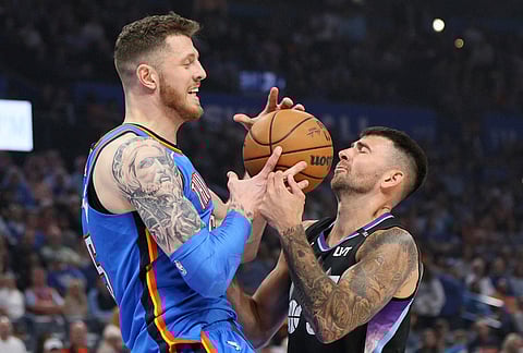 Utah Jazz guard John Konchar, right, knocks the ball away from Oklahoma City Thunder center Isaiah Hartenstein, left, during the first half of an NBA basketball game in Oklahoma City.