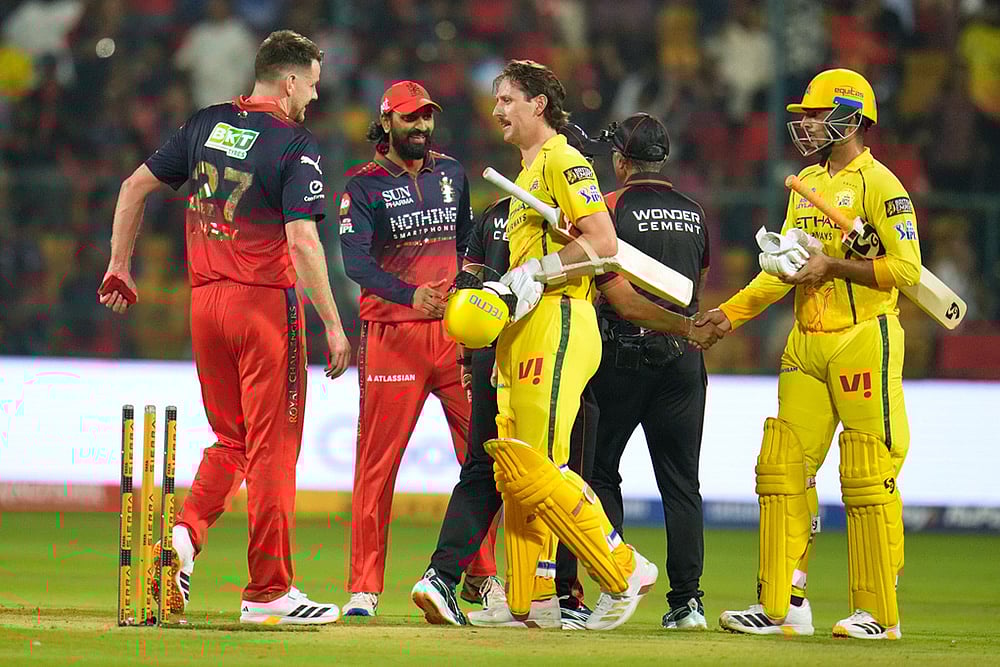 Photo: AP/Aijaz Rahi : Royal Challengers Bengaluru's Jacob Duffy, left, walks to shake hands with Chennai Super Kings' Matt Henry after Royal Challengers Bengaluru won the Indian Premier League cricket match against Chennai Super Kings in Bengaluru, India.