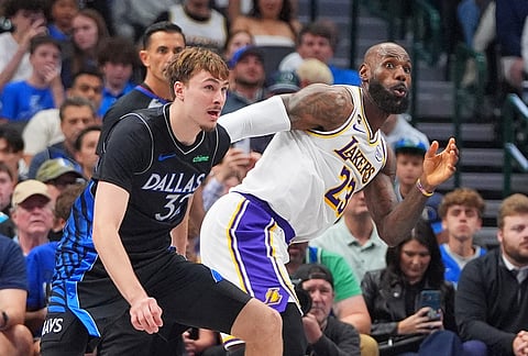 Dallas Mavericks forward Cooper Flagg (32) and Los Angeles Lakers defenders LeBron James (23) play off the ball during the second half of an NBA basketball game in Dallas.