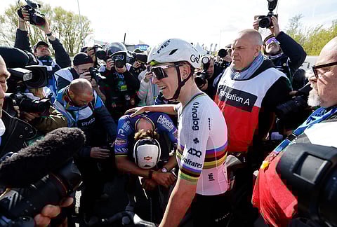 Slovenia's Tadej Pogacar pats on the back Netherland's Mathieu Van Der Poel afternoon winning the Tour of Flanders cycling race, in Oudenaarde, Belgium.