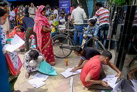 People gather to submit petitions before the Special Tribunal after their names were deleted from the Special Intensive Revision final voter list ahead of the West Bengal Assembly elections, in Balurghat, Dakshin Dinajpur district.