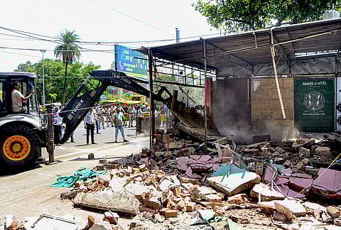 Municipal and district administration officials use an excavator to remove encroachments within 50 metres of the Full Tank Level of the Upper Lake, in compliance with Bhoj Wetland rules, at Bhadbhada locality in Bhopal. 