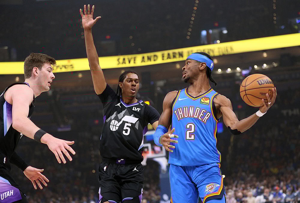 Oklahoma City Thunder guard Shai Gilgeous-Alexander (2) looks to pass the ball away from Utah Jazz forwards Cody Williams (5) and Kyle Filipowski, left, during the first half of an NBA basketball game in Oklahoma City.  - | Photo: AP/Nate Billings