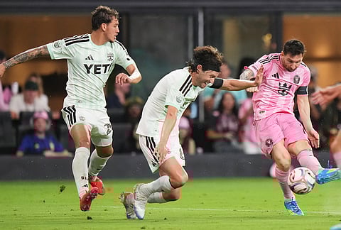Inter Miami CF forward Lionel Messi (10) takes a shot on the goal as Austin FC midfielder Ilie Sánchez, center, during the second half of an MLS soccer match, in Miami. 