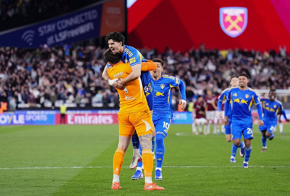 Leeds United goalkeeper Lucas Perri, left, celebrates with Pascal Struijk, top, and teammates after winning the penalty shoot-out during the English FA Cup quarterfinal soccer match between West Ham United and Leeds United, in London. - | Photo: John Walton/PA via AP