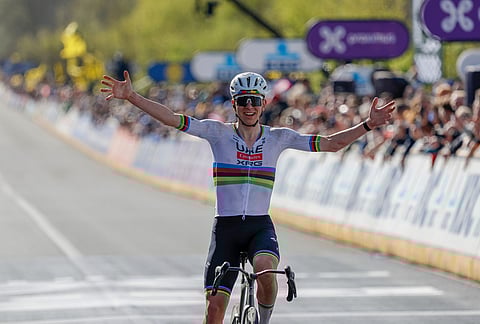 Slovenia's Tadej Pogacar crosses the finish line to win the Tour of Flanders cycling race, in Oudenaarde, Belgium.