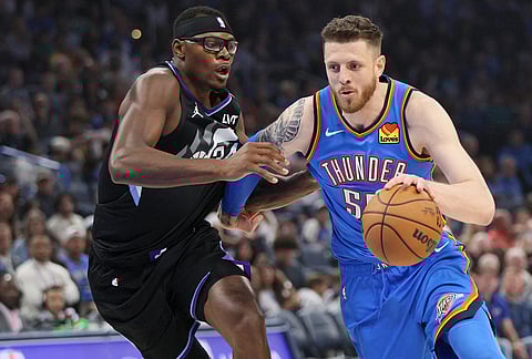 Oklahoma City Thunder center Isaiah Hartenstein, right, drives against Utah Jazz center Oscar Tshiebwe during the first half of an NBA basketball game in Oklahoma City. 