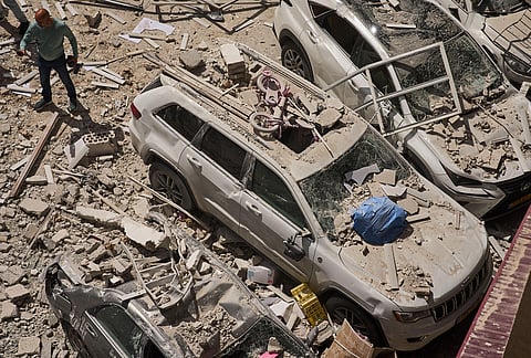 A man inspects the damage to cars and an apartment building struck by an Iranian missile in Ramat Gan, Israel.