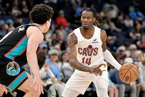 Cleveland Cavaliers guard Keon Ellis (14) handles the ball against Memphis Grizzlies forward Tyler Burton Jr., left. in the first half of an NBA basketball game in Memphis, Tenn.