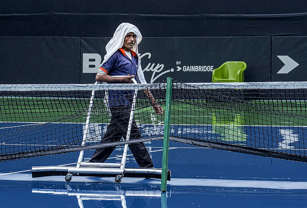 Ground staff clear rainwater ahead of Billie Jean King Cup in Delhi