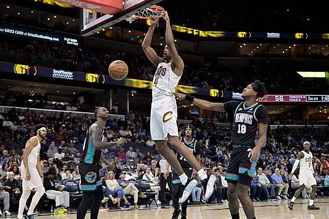 Cleveland Cavaliers center Evan Mobley (4) dunks ahead of Memphis Grizzlies forward Olivier-Maxence Prosper (18) in the first half of an NBA basketball game  in Memphis, Tenn.