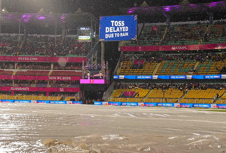 View of the ground covered due to rain as a screen displays 'Toss delayed due to rain' during an Indian Premier League (IPL) 2026 T20 cricket match between Rajasthan Royals and Mumbai Indians, in Guwahati. - | Photo: PTI/Swapan Mahapatra