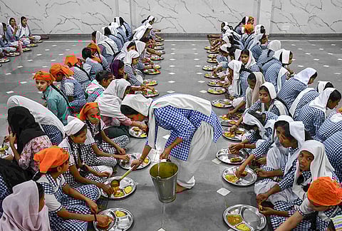 People eat 'langar', free food served in gurudwaras, to mark the birth anniversary of Guru Tegh Bahadur, the ninth of ten Sikh gurus, in Prayagraj, Uttar Pradesh.