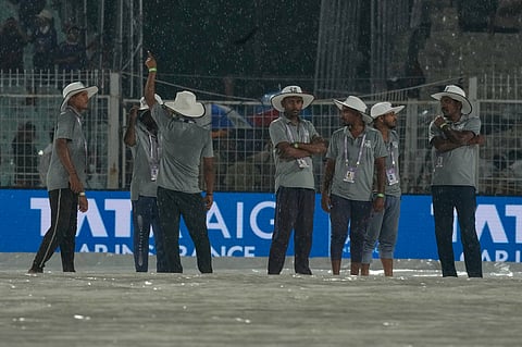 Ground staff stand on rain covers as it rains during the Indian Premier League cricket match between Kolkata Knight Riders and Punjab Kings in Kolkata , India, Monday, April 6, 2026