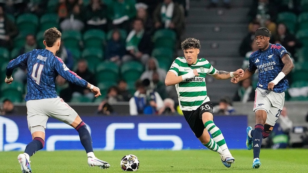 Arsenal's Ben White, left, and Arsenal's Noni Madueke challenge Sporting's Maximiliano Araujo during the Champions League quarterfinals, first leg, soccer match between Sporting CP and Arsenal, in Lisbon, Tuesday, April 7, 2026. - AP Photo/Armando Franca
