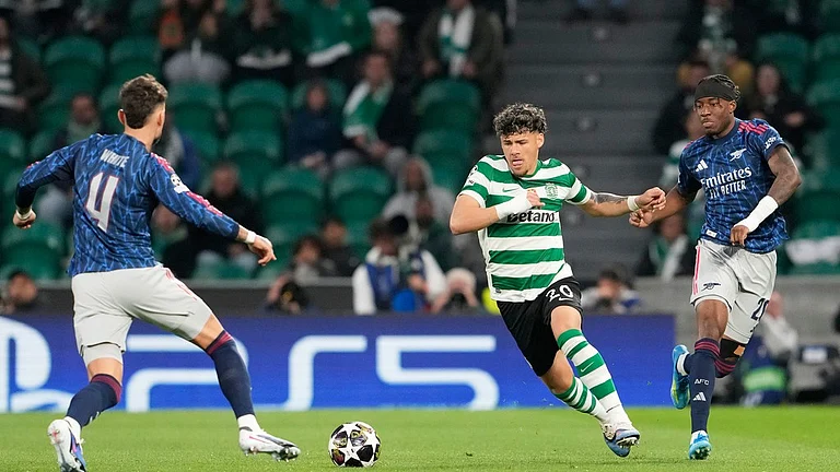 Arsenal's Ben White, left, and Arsenal's Noni Madueke challenge Sporting's Maximiliano Araujo during the Champions League quarterfinals, first leg, soccer match between Sporting CP and Arsenal, in Lisbon, Tuesday, April 7, 2026. - AP Photo/Armando Franca