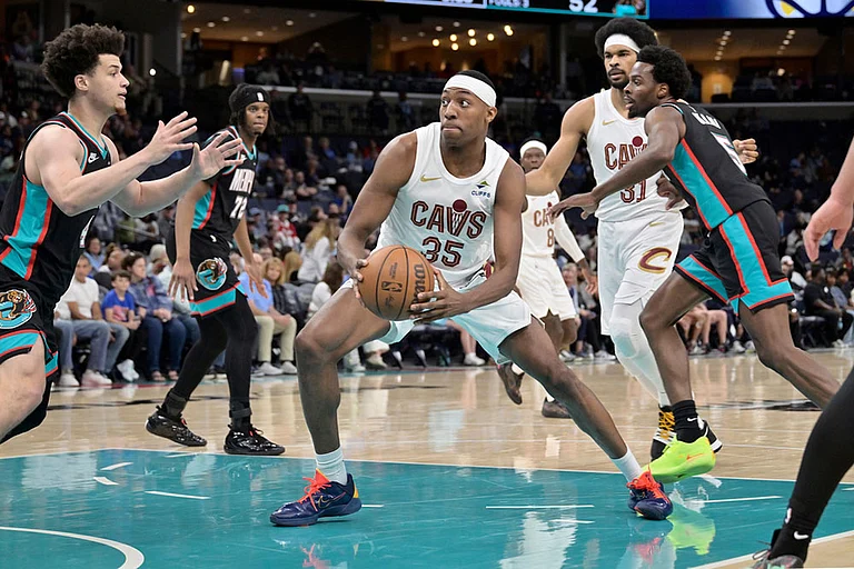 Cleveland Cavaliers forward Nae'qwan Tomlin (35) handles the ball between Memphis Grizzlies guard Walter Clayton Jr., left, and forward Toby Okani (5) in the first half of an NBA basketball game in Memphis, Tenn. - | Photo: AP/Brandon Dill