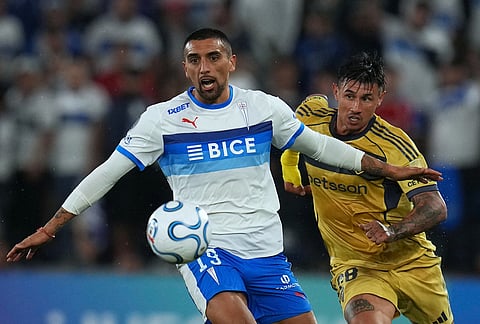 Erwin Ampuero of Chile's Universidad Catolica left, is challenged by Adam Bareiro of Argentina's Boca Juniors during a Copa Libertadores Group D soccer match in Santiago, Chile.