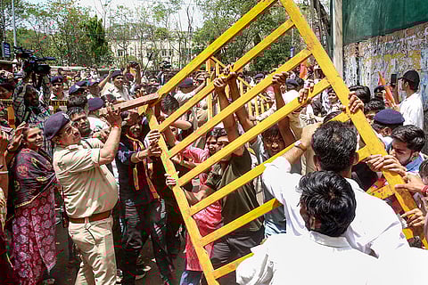 Police stop Akhil Bharatiya Vidyarthi Parishad (ABVP) members as they stage a protest demanding the removal of liquor shops located near educational institutions, in Bhopal.