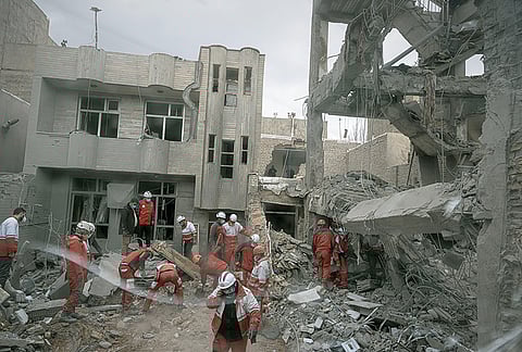 First responders inspect the remains of a residential building hit in an overnight strike during the U.S.-Israeli military campaign in Tabriz, Iran, March 24, 2026. 