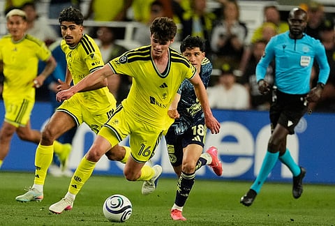 Nashville SC midfielder Matthew Corcoran (16) moves the ball up the field past Club America defender Aaron Mejía (18) during the second half of an CONCACAF Champions Cup first leg quarterfinal soccer match in Nashville, Tennessee.