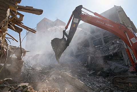 An excavator removes rubble at the site of a strike that, according to a security official at the scene, destroyed half of the Khorasaniha Synagogue and nearby residential buildings in Tehran, Iran, Tuesday, April 7, 2026. 