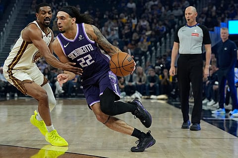 Sacramento Kings guard Devin Carter (22) moves the ball while defended by Golden State Warriors guard De'Anthony Melton during the first half of an NBA basketball game in San Francisco.