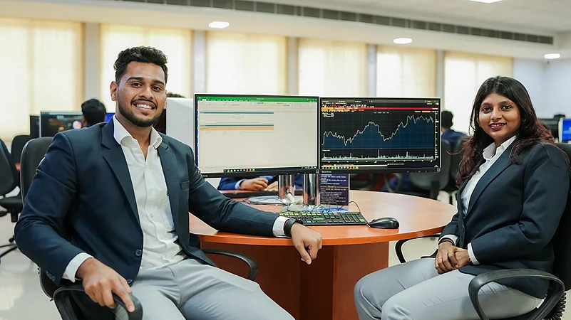 Two professionals in blazers smiling at a desk