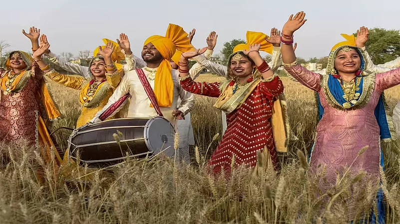 People dancing Bhangra in a wheat field to celebrate Vaisakhi