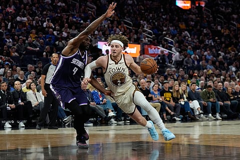 Golden State Warriors guard Brandin Podziemski (2) moves the ball while defended by Sacramento Kings forward Precious Achiuwa (9) during the second half of an NBA basketball game in San Francisco.