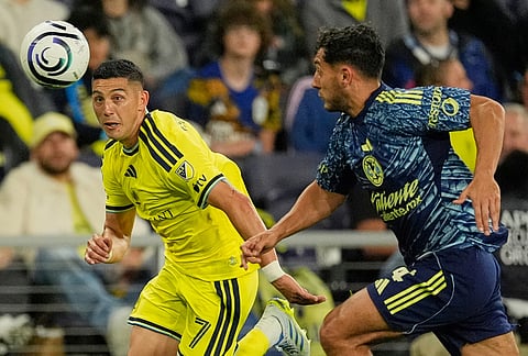 Nashville SC forward Cristian Espinoza (7) chases the ball past Club America defender Sebastian Caceres, right, during the second half of an CONCACAF Champions Cup first leg quarterfinal soccer match in Nashville, Tennessee.