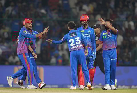 Delhi Capitals' Kuldeep Yadav, centre, celebrates with teammates the wicket of Gujarat Titans' Jos Buttler during the Indian Premier League cricket match between Delhi Capitals and Gujarat Titans in New Delhi.
