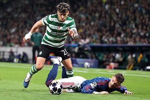 Sporting's Maximiliano Araujo, left, challenges Arsenal's Ben White during the Champions League quarterfinals, first leg, soccer match between Sporting CP and Arsenal, in Lisbon.